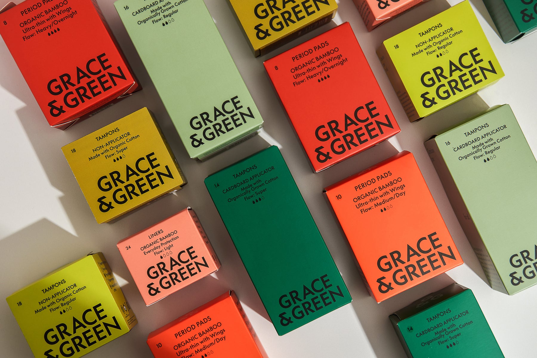 Various Grace & Green period products including tampons and pads in colorful packaging