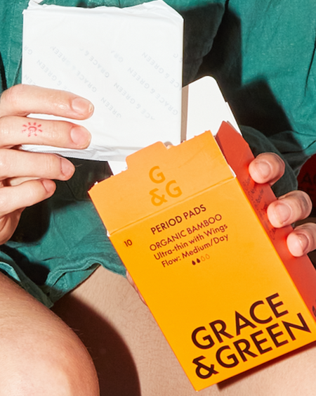 Grace & Green period pads being held from the box.